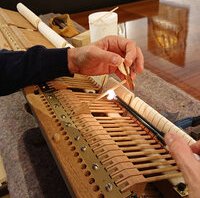 Pleyel F 1933 - alignement des têtes de marteaux • en chauffant les manches, on règle la parfaite équidistance des marteaux, et leur verticalité